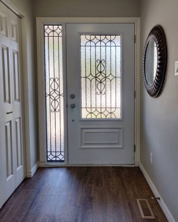 A custom wrought iron insert in a single door with a sidelite