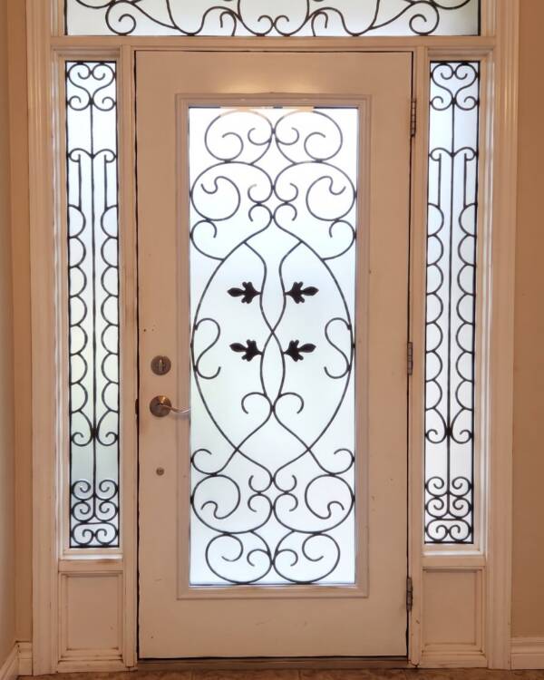 A custom wrought iron insert with sidelites and a transom