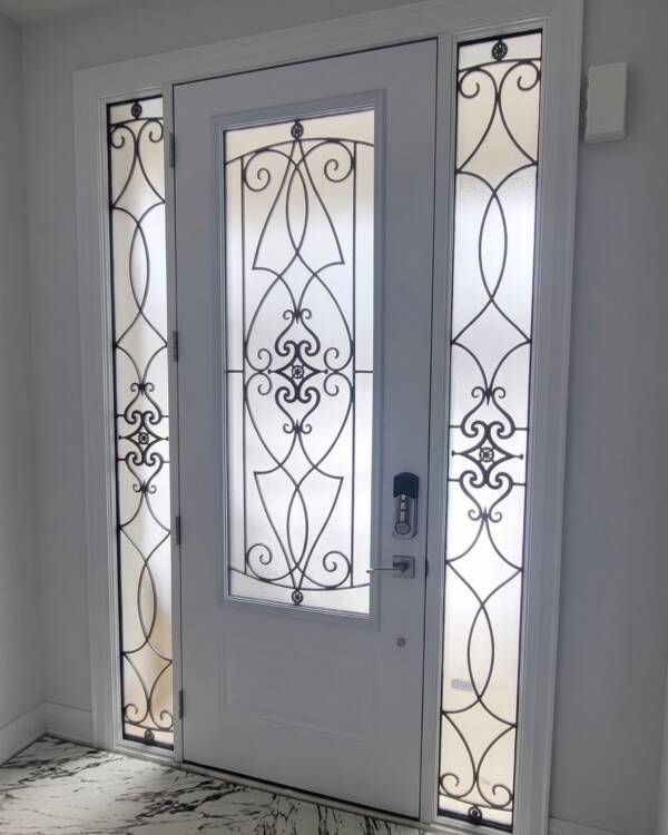 Custom wrought iron inserts in a double door with a transom