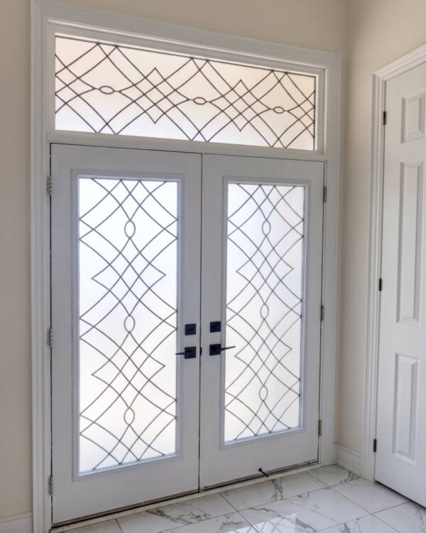Wrought iron inserts in a double door with a transom