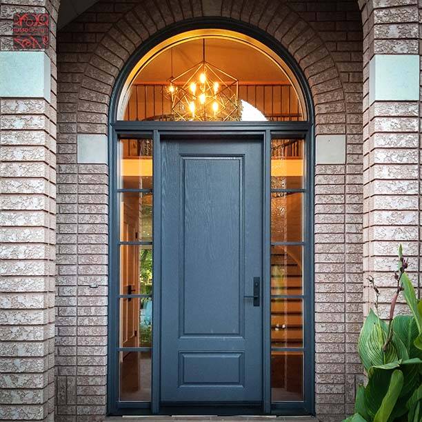 A blue-grey exterior door with sidelites under an arched transom