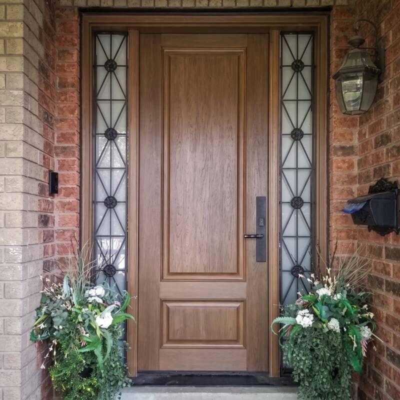 An oak woodgrain door with wrought iron sidelites
