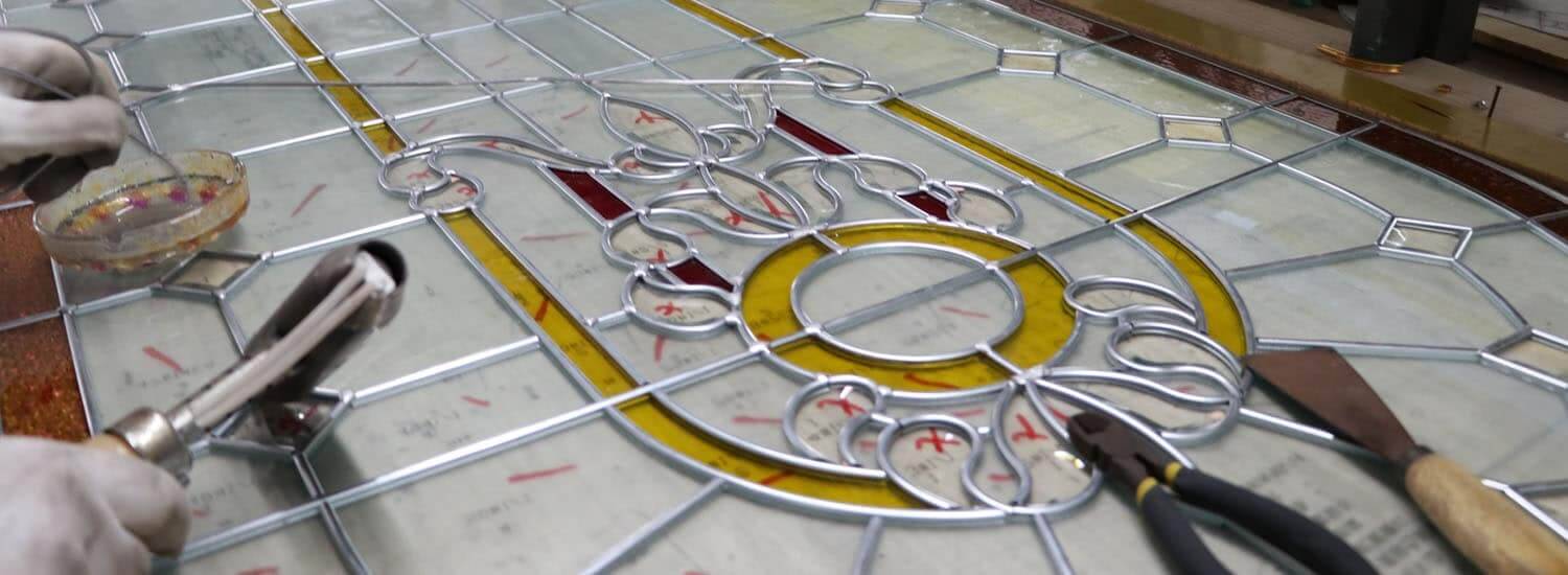 A stained glass panel being leaded by hand