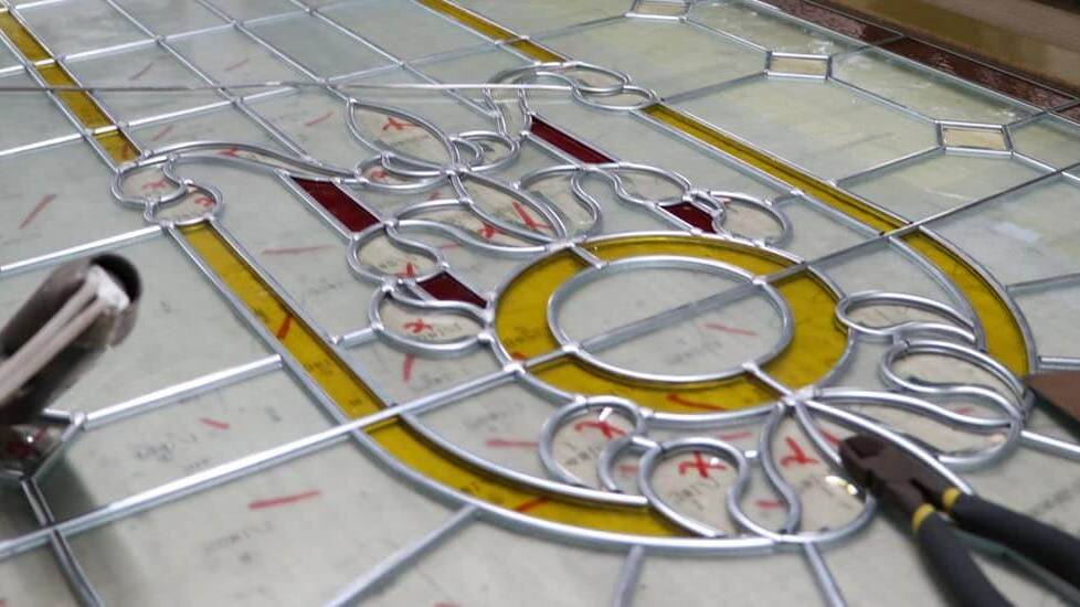 A stained glass panel being leaded by hand