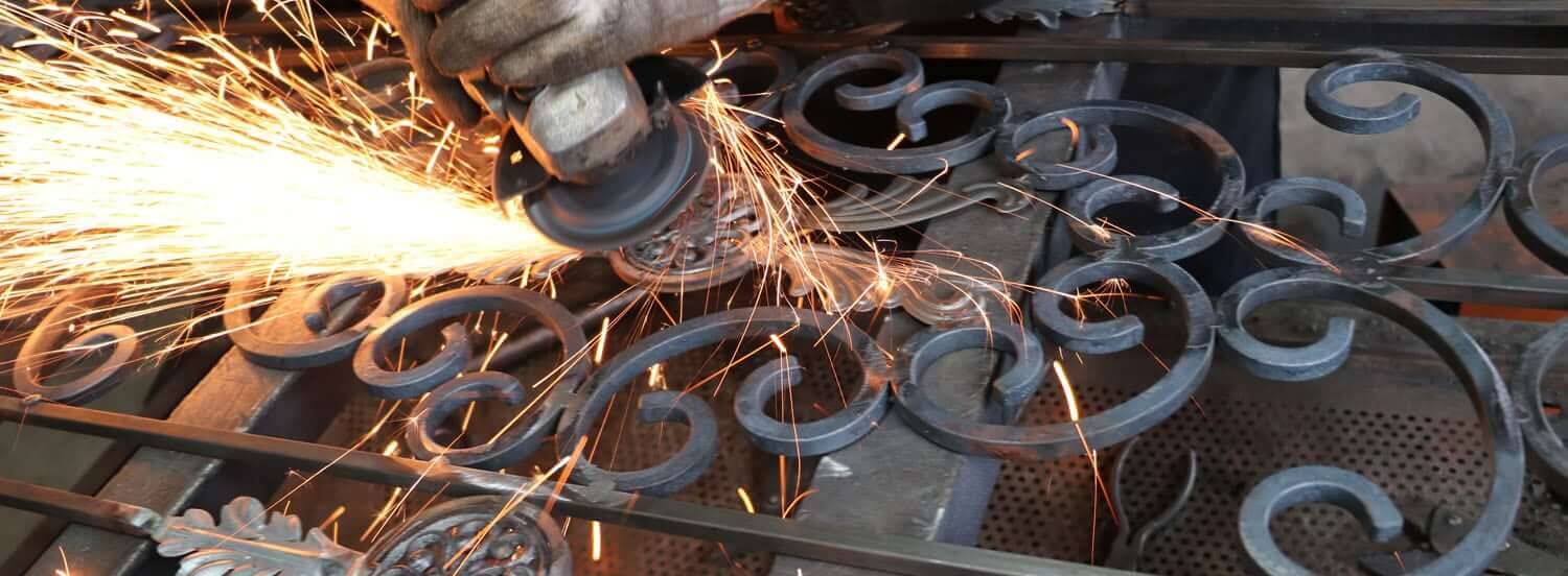 Wrought iron scrollwork being ground, in a shower of sparks