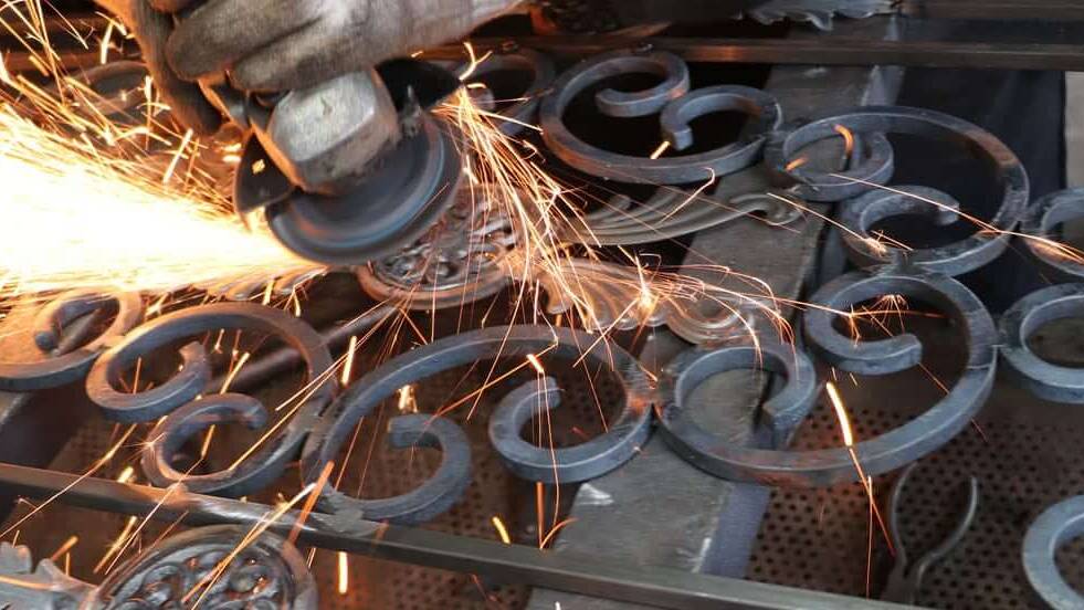 Wrought iron scrollwork being ground, in a shower of sparks