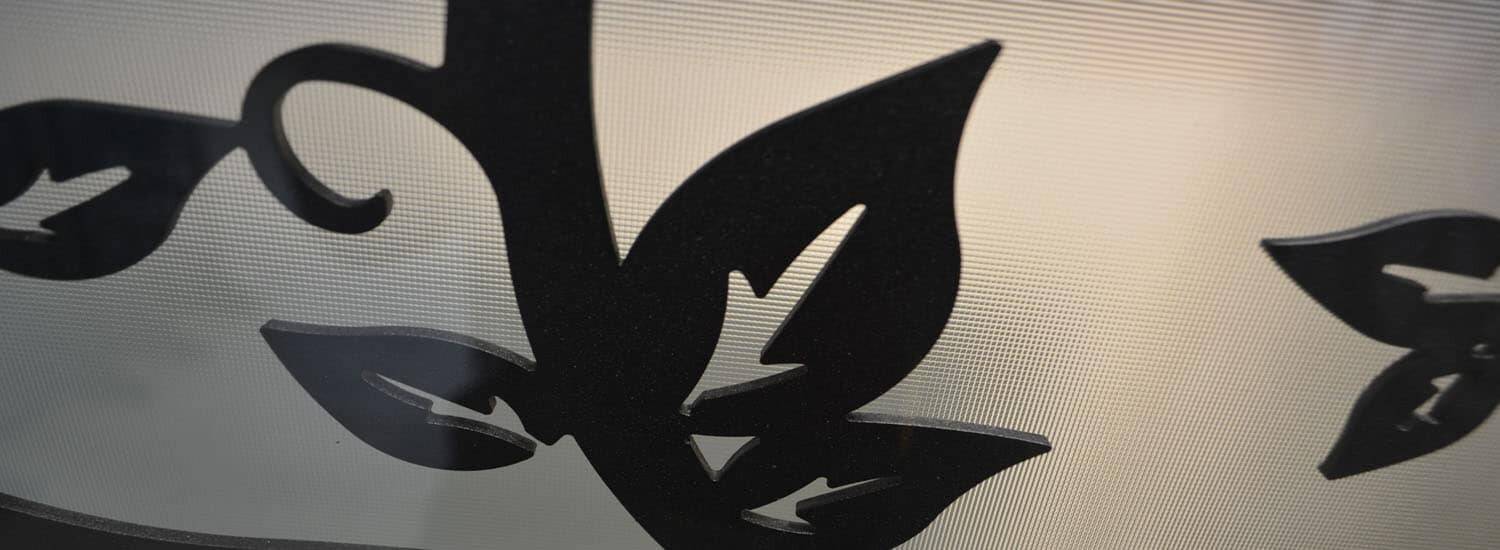 Laser-cut iron leaves against textured glass