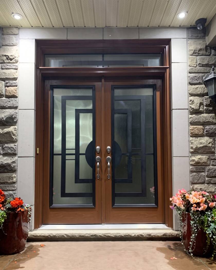Constellation wrought iron inserts in a wood-grain double front door with a transom