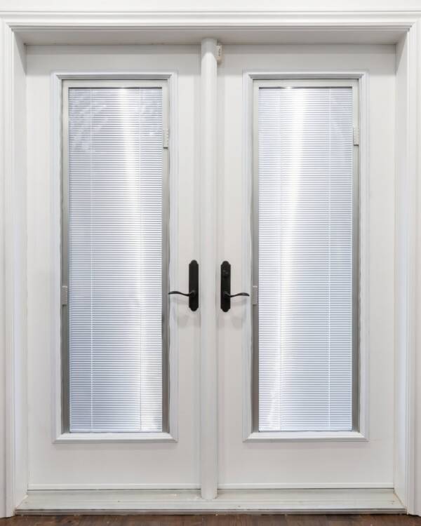 A white double door with silver blinds between the glass