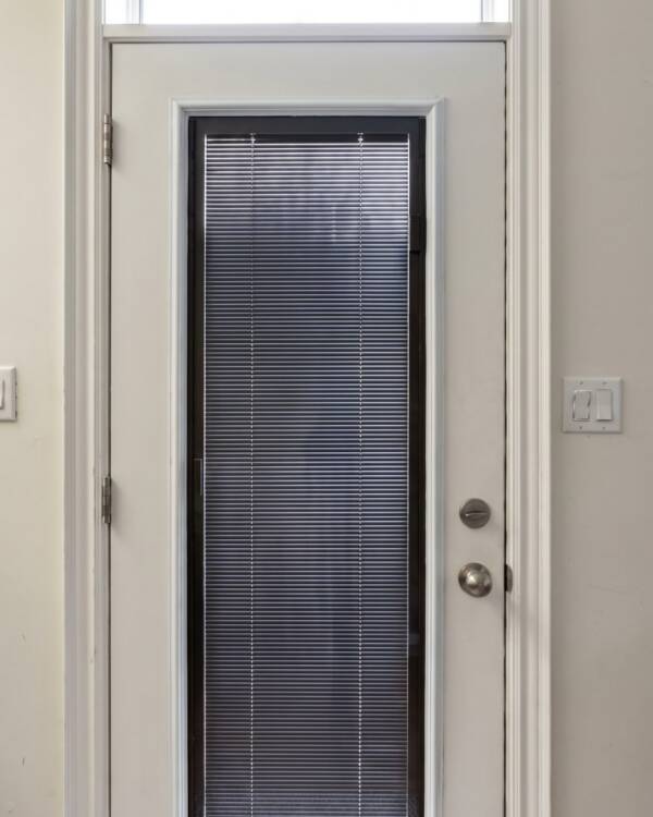 A door with dark coffee blinds between the glass